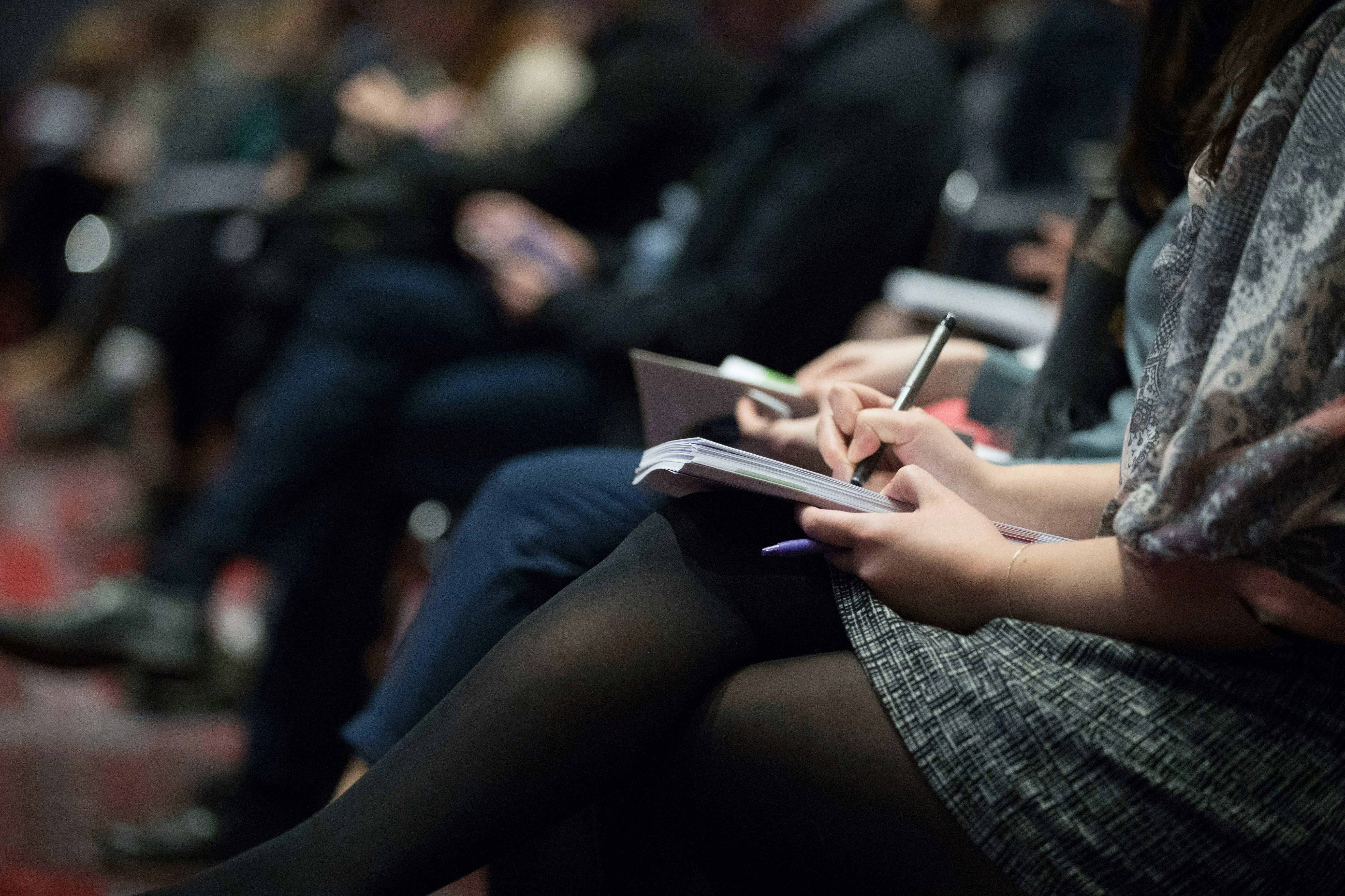 People taking notes at a seminar